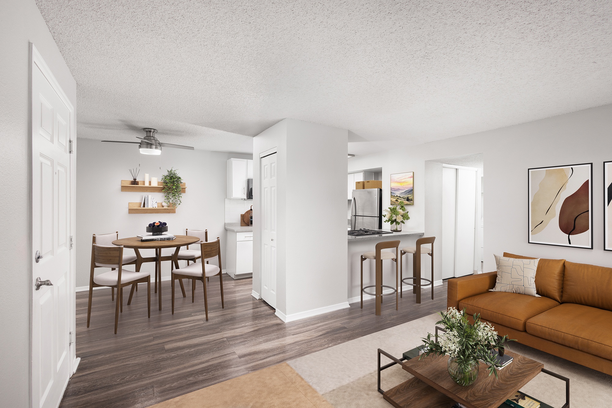 A living room with a brown couch and a dining table with chairs.
